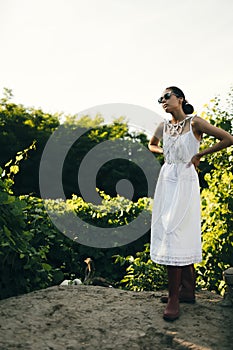 Portrait of a beautiful girl in a white dress in the garden. Burnette beautiful natural girl with in a white dress in