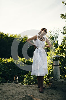 Portrait of a beautiful girl in a white dress in the garden. Burnette beautiful natural girl with in a white dress in