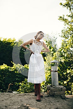 Portrait of a beautiful girl in a white dress in the garden. Burnette beautiful natural girl with in a white dress in