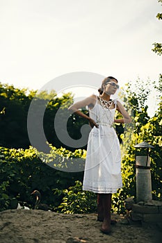 Portrait of a beautiful girl in a white dress in the garden. Burnette beautiful natural girl with in a white dress in