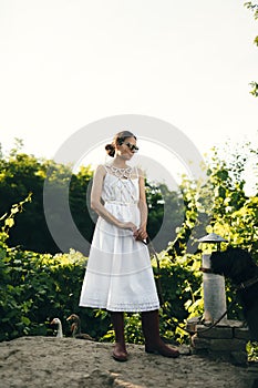 Portrait of a beautiful girl in a white dress in the garden. Burnette beautiful natural girl with in a white dress in