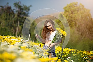 Portrait beautiful girl in white dress relaxing at chrysanthemum garden