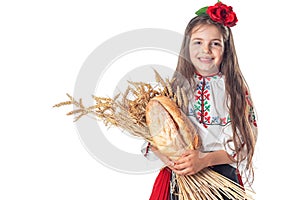 Portrait of a beautiful girl woman in traditional Bulgarian folklore dress holding homemade bread and golden wheat