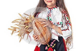 Portrait of a beautiful girl woman in traditional Bulgarian folklore dress holding homemade bread and golden wheat