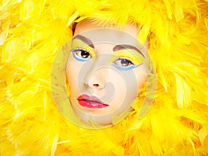 Portrait of beautiful girl in yellow feathers. Perfect makeup