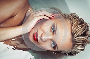 Portrait of a beautiful glamourous blonde in water, spa concept photo