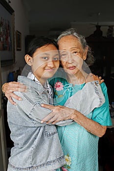 Portrait of Beautiful Grandmother and Teenage Granddaughter Hugging and Smiling Happy to See Each Other