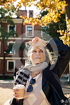 Portrait of  beautiful gray-haired elderly woman in  park on  bench