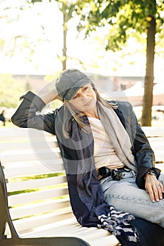 Portrait of  beautiful gray-haired elderly woman in  park on  bench