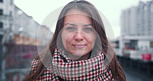 Portrait of beautiful happy 30s brunette Caucasian woman smiling at camera, rolling eyes in city background slow motion.