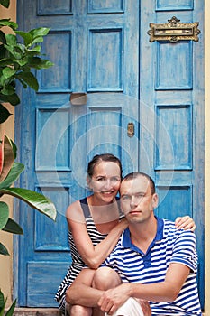 Portrait of beautiful and happy couples on background of blue door