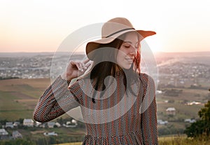 Portrait of a beautiful happy girl on a city background at sunset.