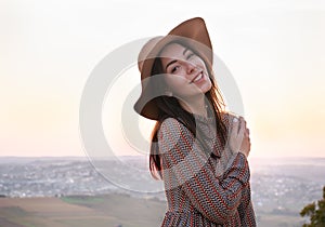 Portrait of a beautiful happy girl on a city background at sunset