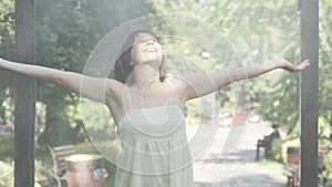 Portrait of beautiful happy relaxed Caucasian woman refreshing under water drops outdoors. Cheerful carefree lady