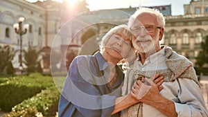 Portrait of beautiful happy senior couple bonding to each other and holding hands while standing in the park together