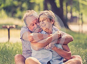 Portrait of a beautiful happy senior couple in love relaxing in the park