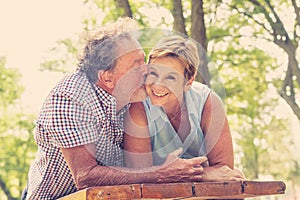 Portrait of a beautiful happy senior couple in love relaxing in the park