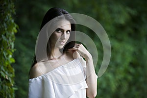 Portrait of a beautiful happy smiling caucasian woman in white dress with open shoulders, clean skin, long hair and casual makeup