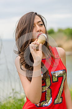 Portrait of beautiful happy smiling emotional young woman eating delicious ice cream