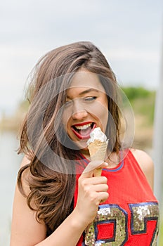 Portrait of beautiful happy smiling emotional young woman eating delicious ice cream