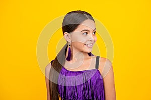 Portrait of beautiful happy smiling teenage girl on yellow studio background.