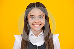 Portrait of beautiful happy smiling teenage girl on yellow studio background.