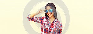Portrait of beautiful happy smiling young brunette woman in sunglasses on white background