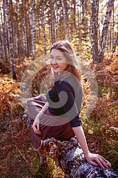 Portrait of a beautiful happy woman with a smile in autumn yellow leaf forest or park, seasonal enjoy time, september weather