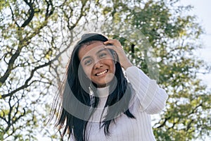 Portrait of a beautiful happy young Latin woman against the light with the sun at her back