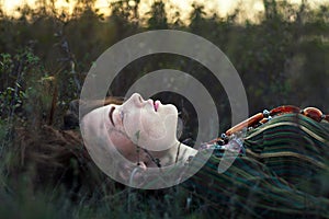 Portrait of beautiful hippie girl lying on the grass