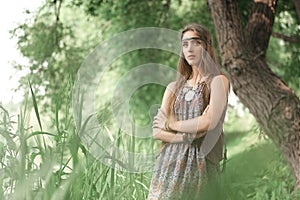 Beautiful hippie girl standing among trees in forest