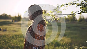 Portrait of an beautiful hippie woman with dreadlocks in the woods at sunset having good time outdoors