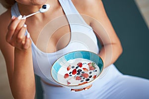 Portrait of beautiful hispanic woman eating yoghurt promoting healthy lifestyle