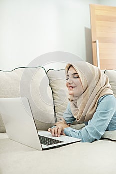 Beautiful housewife wearing hijab enjoy browsing on laptop in a