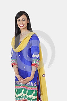 Portrait of beautiful Indian female traditional wear standing against gray background