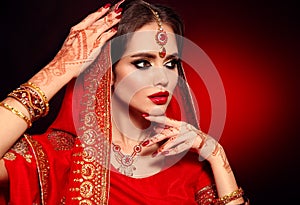 Portrait of beautiful indian girl in red bridal sari. Young hindu woman model with kundan jewelry set. Traditional Indian costume