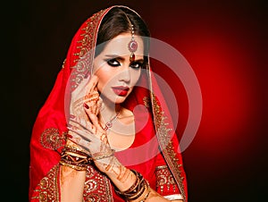 Portrait of beautiful indian girl in red bridal sari. Young hindu woman model with kundan jewelry set. Traditional Indian costume