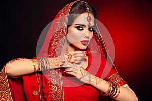 Portrait of beautiful indian girl in red bridal sari. Young hindu woman model with kundan jewelry set. Traditional Indian costume