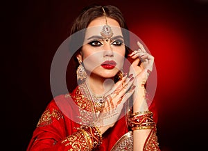 Portrait of beautiful indian girl in red bridal sari. Young hindu woman model with kundan jewelry set. Traditional Indian costume