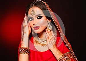 Portrait of beautiful indian girl in red bridal sari. Young hindu woman model with kundan jewelry set. Traditional Indian costume
