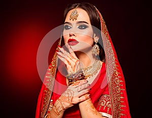 Portrait of beautiful indian girl in red bridal sari. Young hindu woman model with kundan jewelry set. Traditional Indian costume