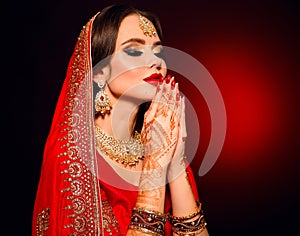 Portrait of beautiful indian girl in red bridal sari. Young hindu woman model with kundan jewelry set. Traditional Indian costume