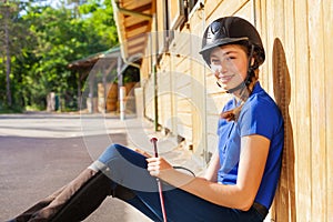 Portrait of beautiful jockey girl at riding stable