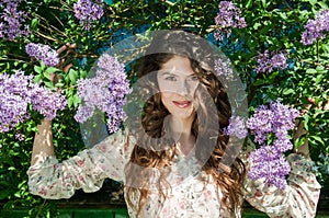 Portrait of beautiful lady in the blooming lilac