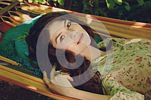 portrait of beautiful lady in the garden hammock, spring or summer seaason, outdoor portrait