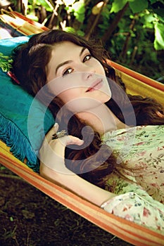 portrait of beautiful lady in the garden hammock, spring or summer seaason, outdoor portrait