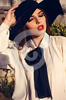 Portrait of beautiful ladylike woman in elegant blouse and hat