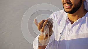 Portrait of beautiful laughing emirate male in sandy desert agai