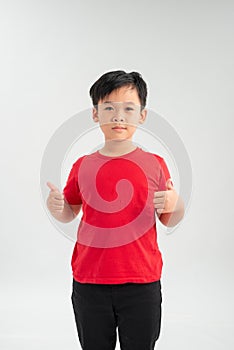 Portrait of beautiful little boy giving you thumbs up over white background