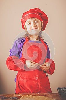 Portrait of beautiful little chef girl preparing homemade pizza